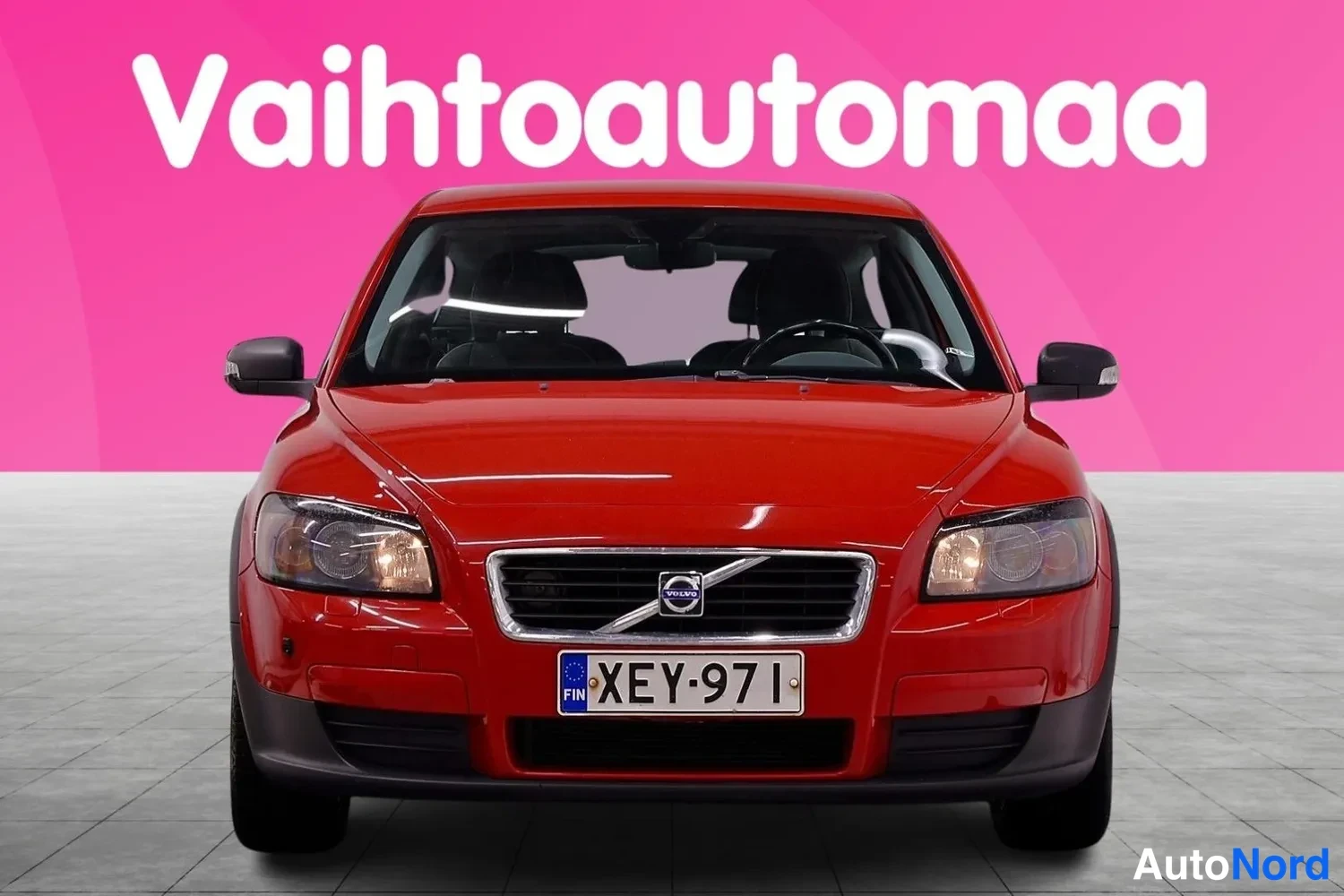 Edestä: Punainen henkilöauto suoraan edestä, rekisterikilpi.