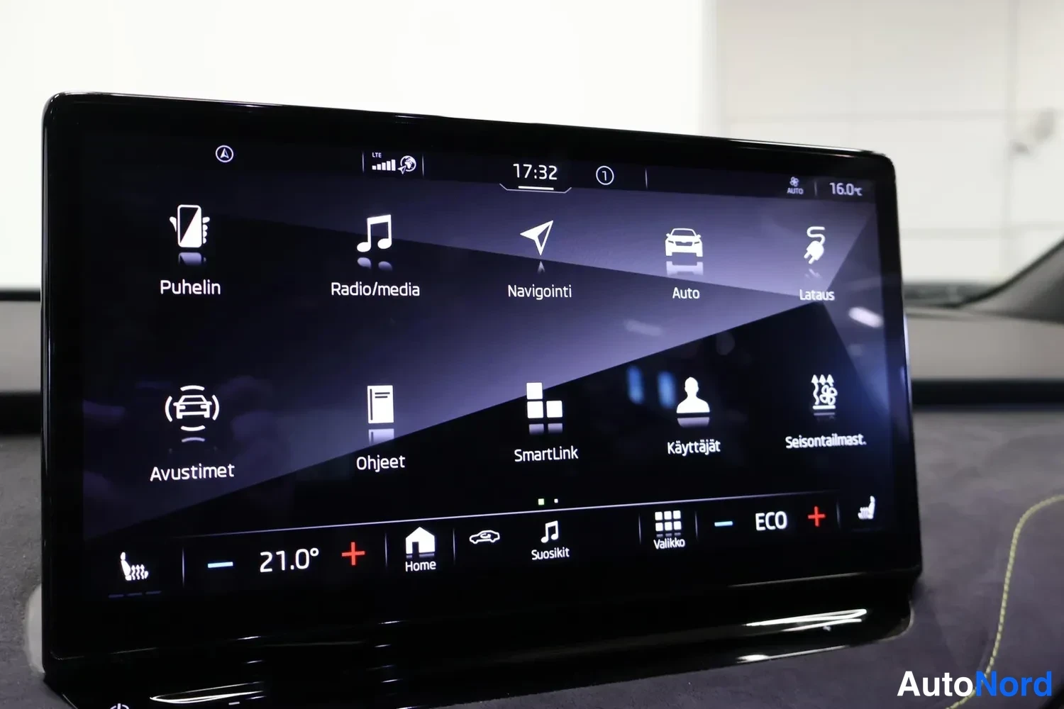 Muu: Infotainment-näytön valikko vaihtoehdoilla Puhelin, Radio/media, Navigointi, Auto, Lataus, Avustimet, Ohjeet, SmartLink, Käyttäjät ja Seisontailmast.