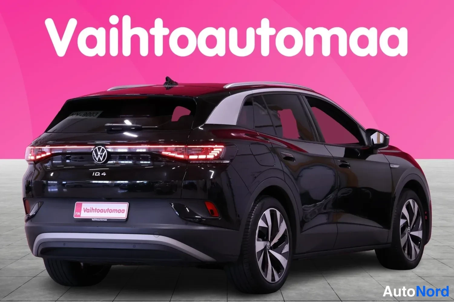 Takaviisto: Mustan Volkswagen ID.4:n takakolmasosan kuva, takavalojen poikittaisvalo ja rekisterikilpi näkyvät.