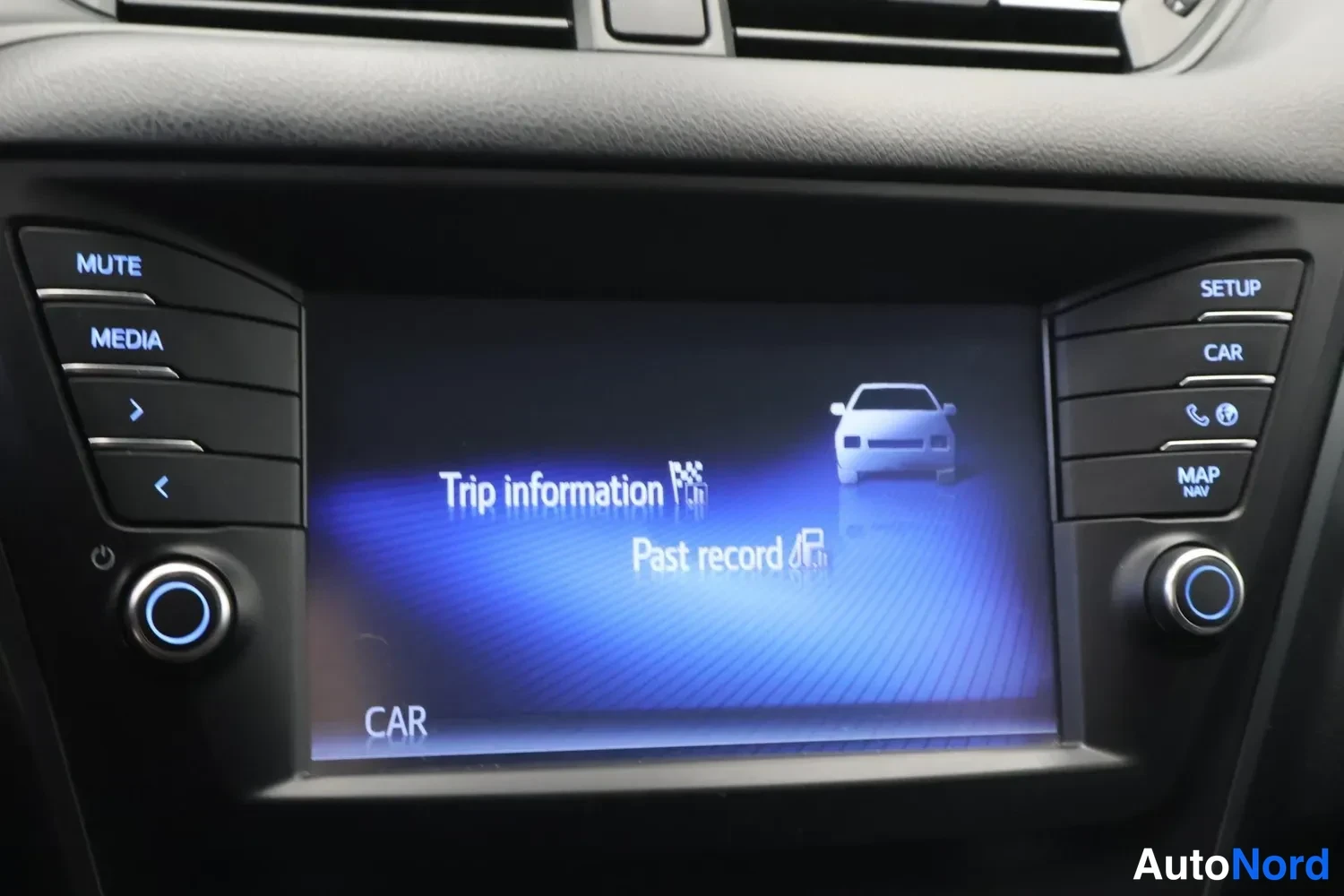Muu: Keskikonsolin näyttö näyttää valikon 'Trip information' ja 'Past record', ympärillä SETUP-, CAR- ja MAP NAV -painikkeet.