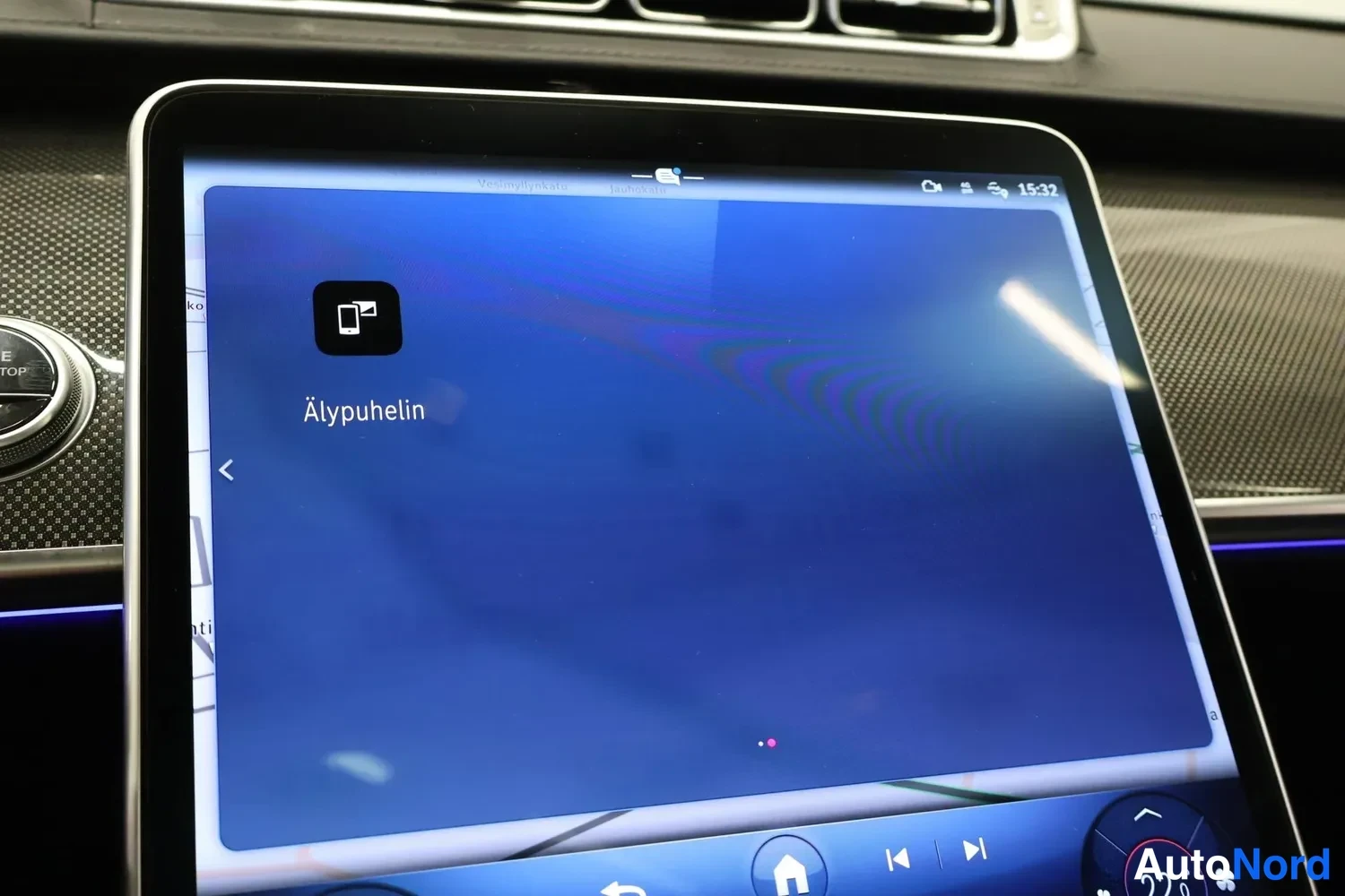 Yksityiskohta: Auton etupöytä; Mercedes-Benz-tähti ja teksti C 200 d näkyvät keskikonsolin näytöllä.