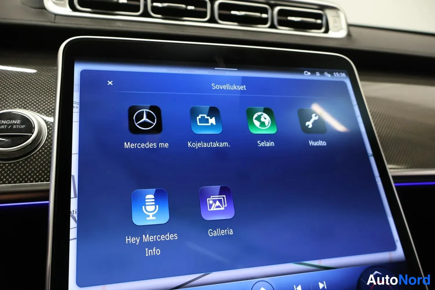 Muu: Auton keskikonsolin näyttö, jossa on auki Sovellukset-valikko: Mercedes me, Kojelautakam., Selain, Huolto, Hey Mercedes Info ja Galleria. Vasemmalla näkyy ENGIN