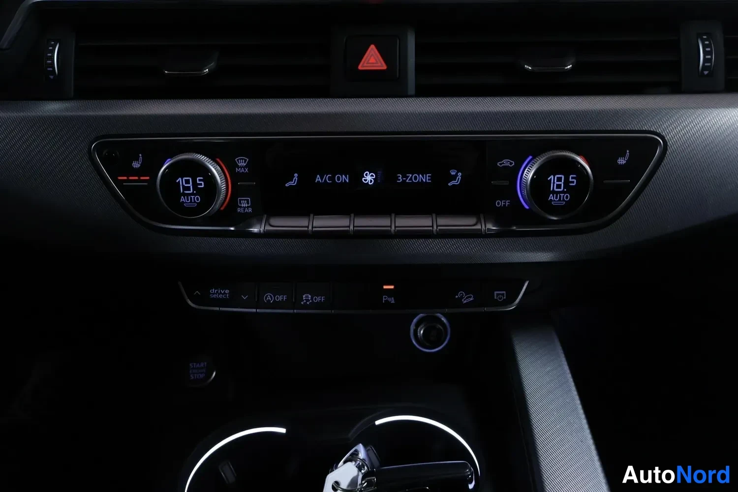 Yksityiskohta: Audi A4 Allroadin keskikonsolin ilmastointipaneeli näyttää kaksivyöhykeisen automaattisäädön lämpötilat 19,5 ja 18,5 astetta, A/C ON ja 3-ZONE -merkinnät sekä d