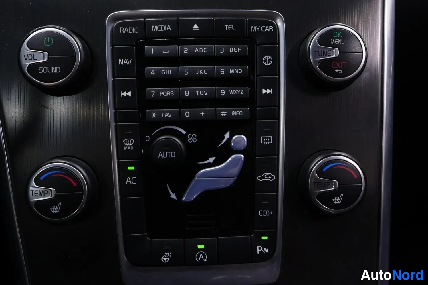 Yksityiskohta: Keskitörmäkilpeen painikkeet: RADIO, MEDIA, TEL, MY CAR, NAV, numeronäppäimet, AUTO ja AC, sekä TEMP- ja VOL/SOUND/TUNE-säätimet.
