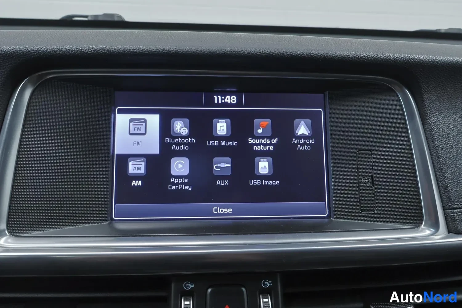 Edestä: Keskinäytön valikko: FM, Bluetooth Audio, USB Music, Sounds of nature, Android Auto, AM, Apple CarPlay, AUX, USB Image, kello 11:48.