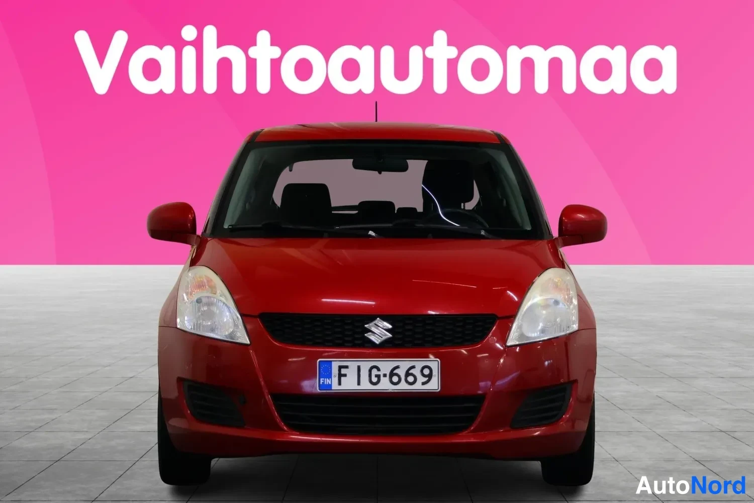 Edestä: Punaisen Suzuki Swiftin etunäkymä, rekisteritunnus.