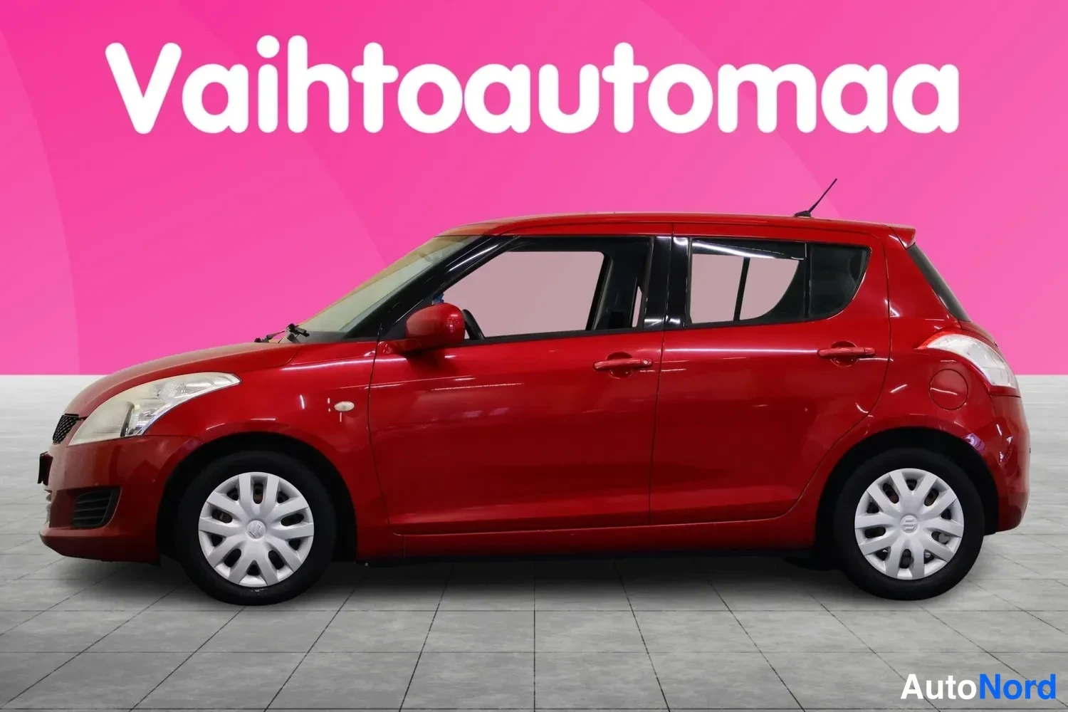 Sivulta: Punainen hatchback sivulta vasemmalta