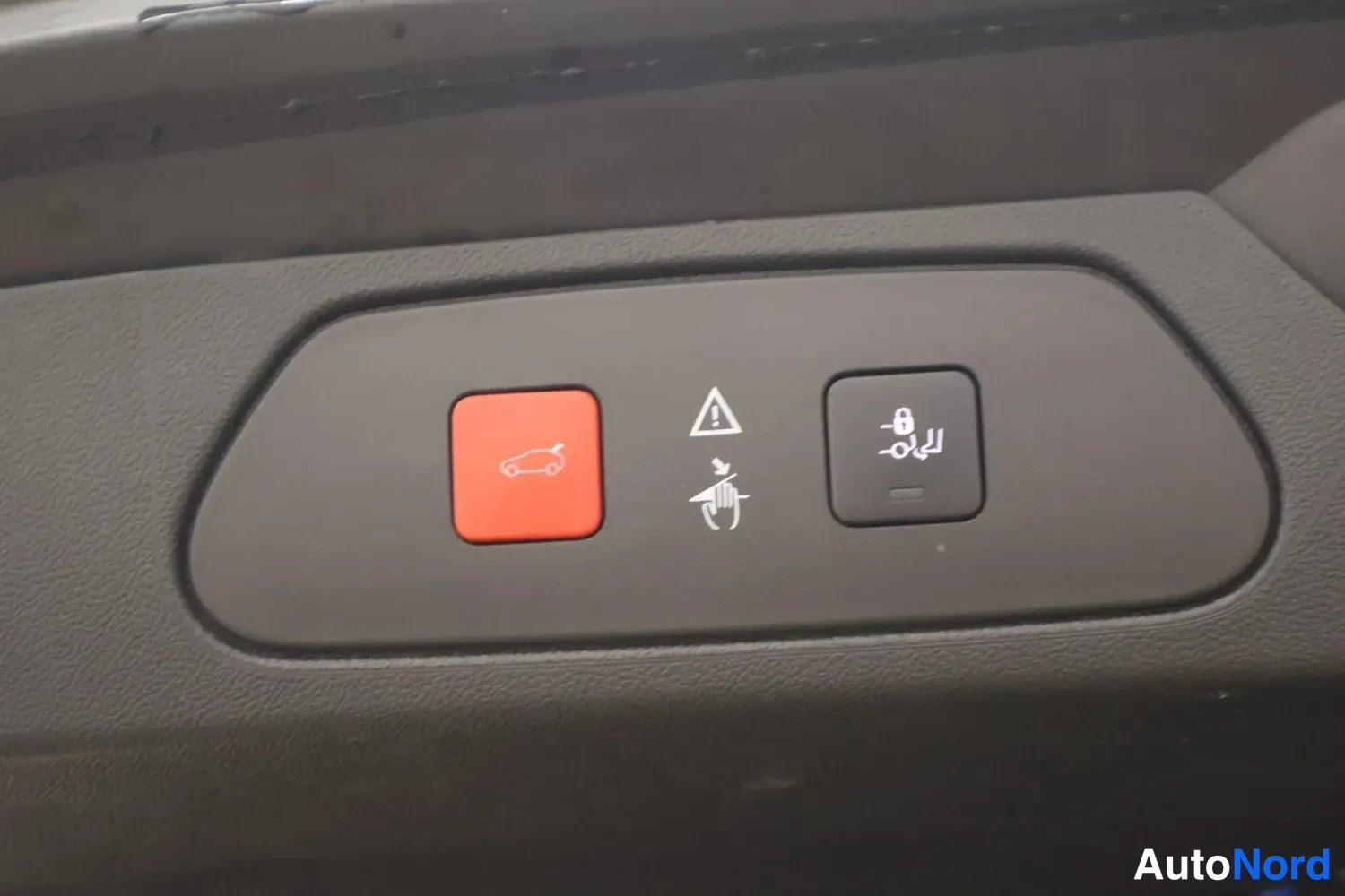 Edestä: Punainen painike, jossa avattava auto-symboli, sekä lukituspainike ja varoituskolmio.