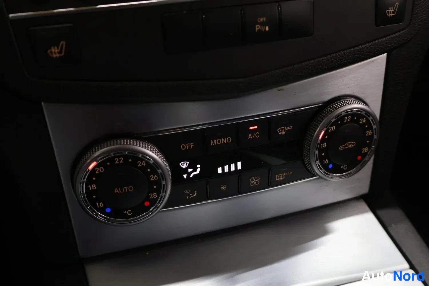 Muu: Sisätilakuva: Mercedesin automaattisen ilmastoinnin ( Thermatic ) keskustan hoidot, pyöreät lämpötilasäätimet (18–28 °C) ja säätöpainikkeet, joissa AUTO , OFF ,