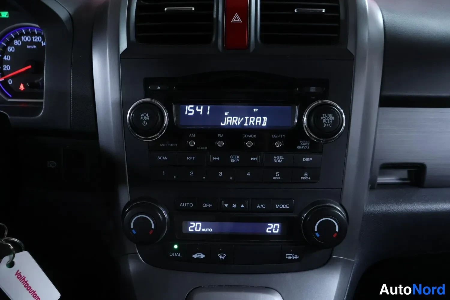 Yksityiskohta: Keskikonsolissa radio (näytössä '1541 JARVIRADIO') ja automaattinen kaksivyöhykeilmastointi, näytössä 20 AUTO 20
