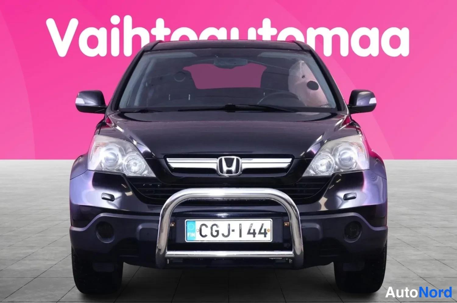 Edestä: Mustansininen Honda CR-V suoraan edestä, kromikaari etupuskurissa ja rekisteri.