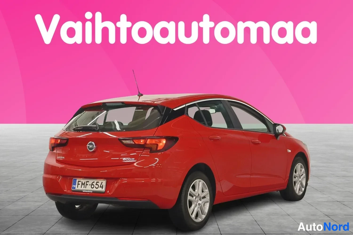Takaviisto: Punaisen Opel Astra -henkilöautin takaosa ja vasen kylki kuvattuna kolmannesaiv kulmasta rekisterikilpi näkyvissä.