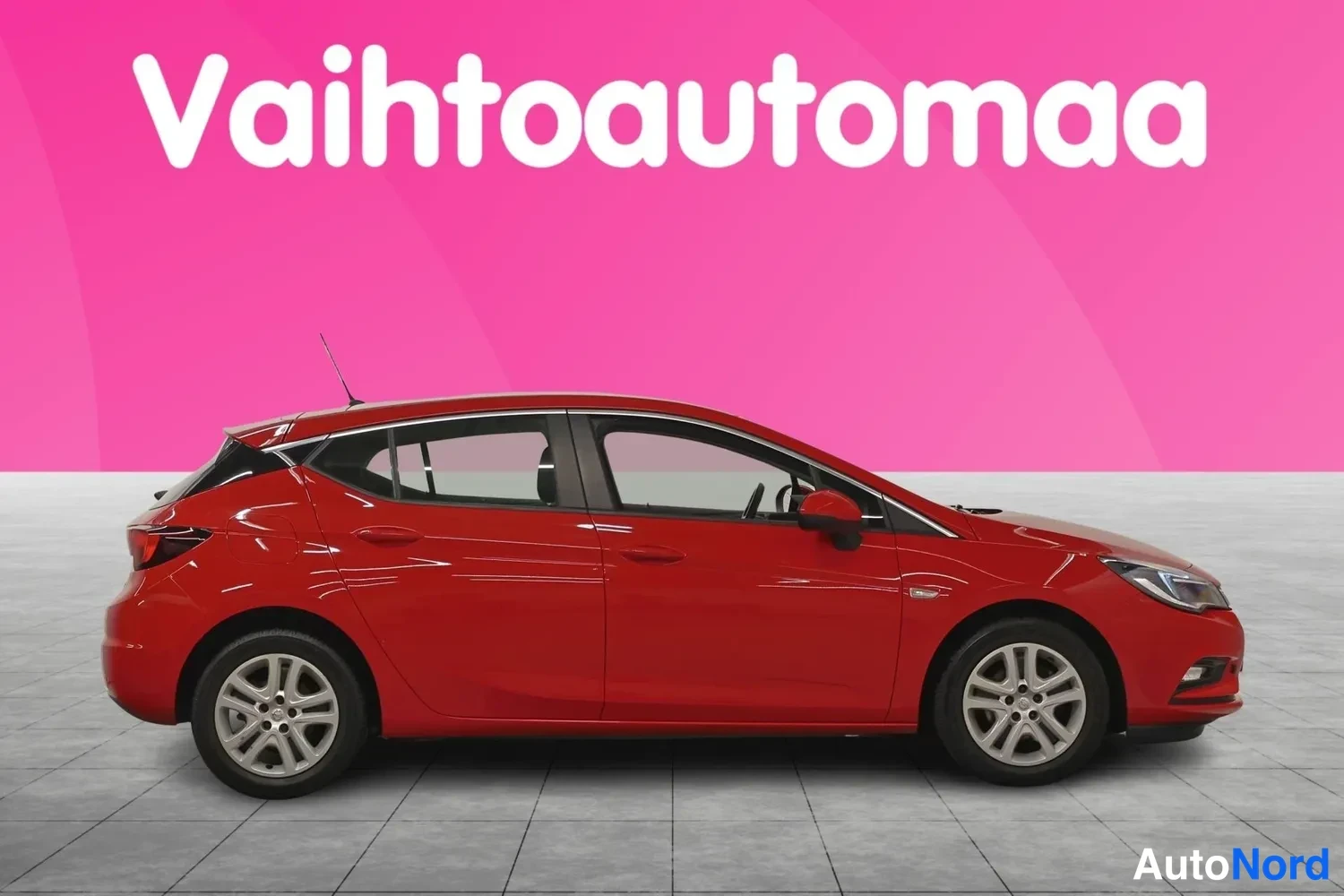 Etuviisto, nokka oikealle: Punaisen Opel Astra -henkilöautin kylki ja etuosa kuvattuna kolmannesaiv kulmasta.