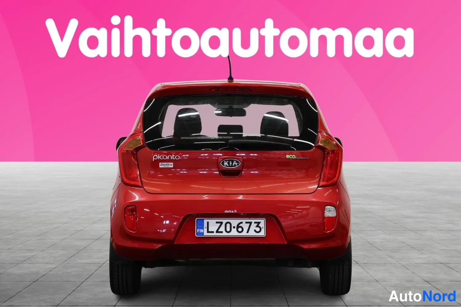 Takaa: Auton takaosan suorakuva punaisesta Kia Picanosta; rekisterikilpi LZ0-673, Kia-merkki ja picanto-teksti takaluukussa, punaiset takavalot.