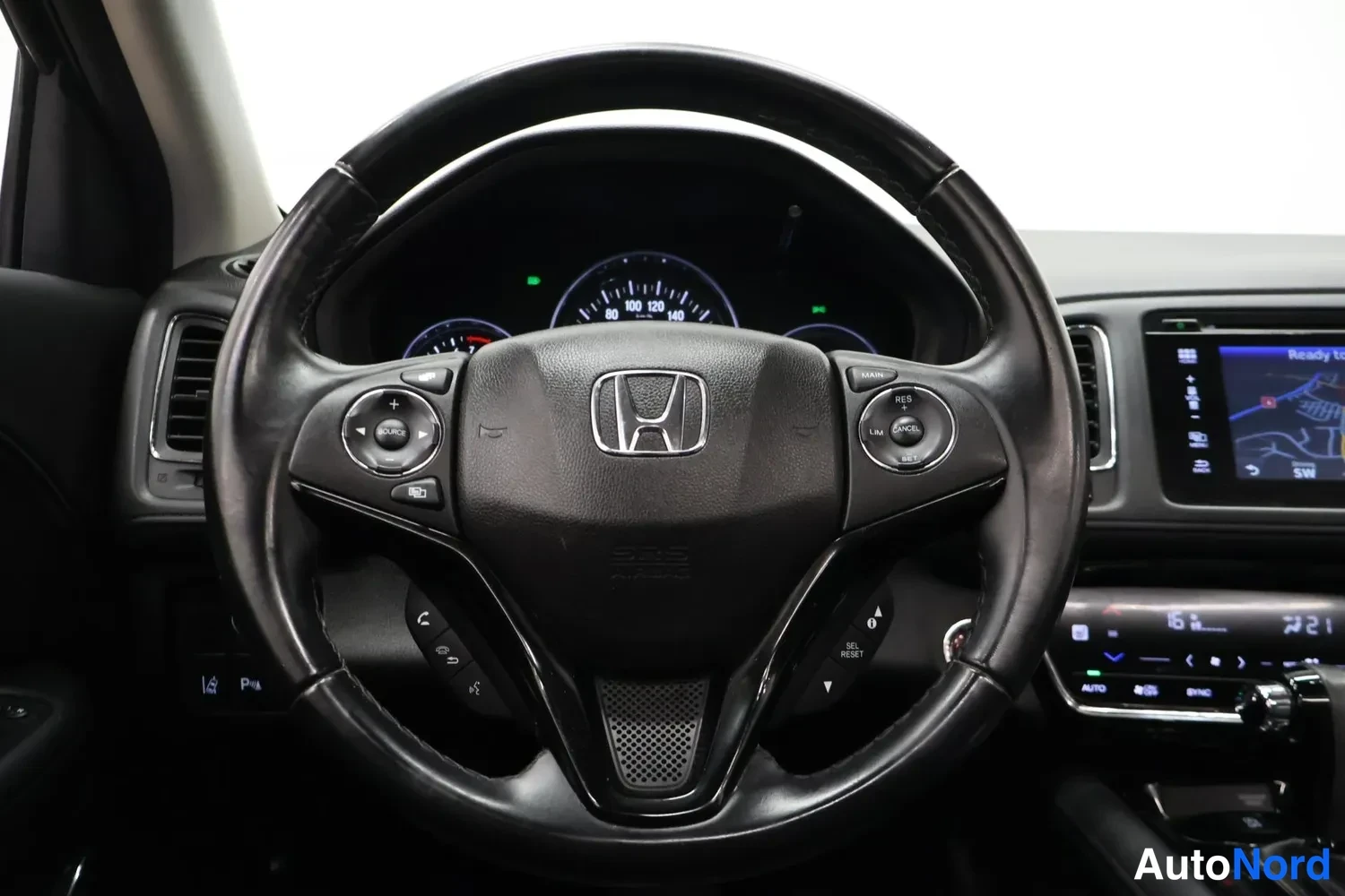 Muu: Honda-ohjauspyörä etukeskuksessa, kojetaulun mittarit ja osa keskinäytöstä näkyvät.