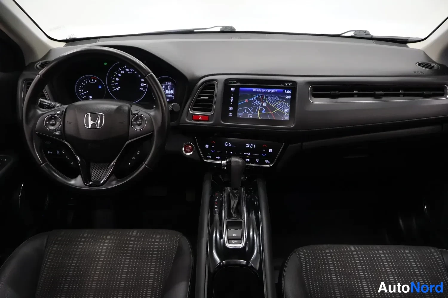 Muu: Honda HR-V:n ohjaamo suoraan edestä: ohjauspyörä, kojelauta, karttanäyttö ja automaattivaihteiston valitsin.
