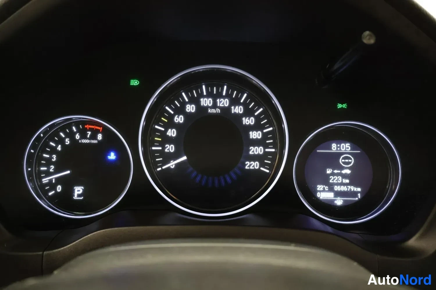 Yksityiskohta: Mittaristo: nopeusmittari 0–220 km/h, kierrosmittari ja kello, jossa lukema 068679 km ja lämpötila 22 °C.