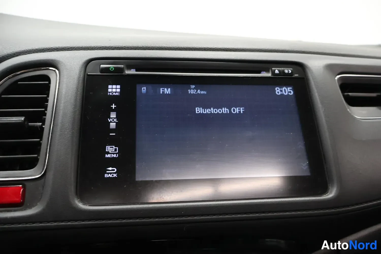 Muu: Kojeiston kosketusnäyttö näyttää FM-radioasemaa 102.4 MHz ja tekstiä Bluetooth OFF; kellonaika 8:05.
