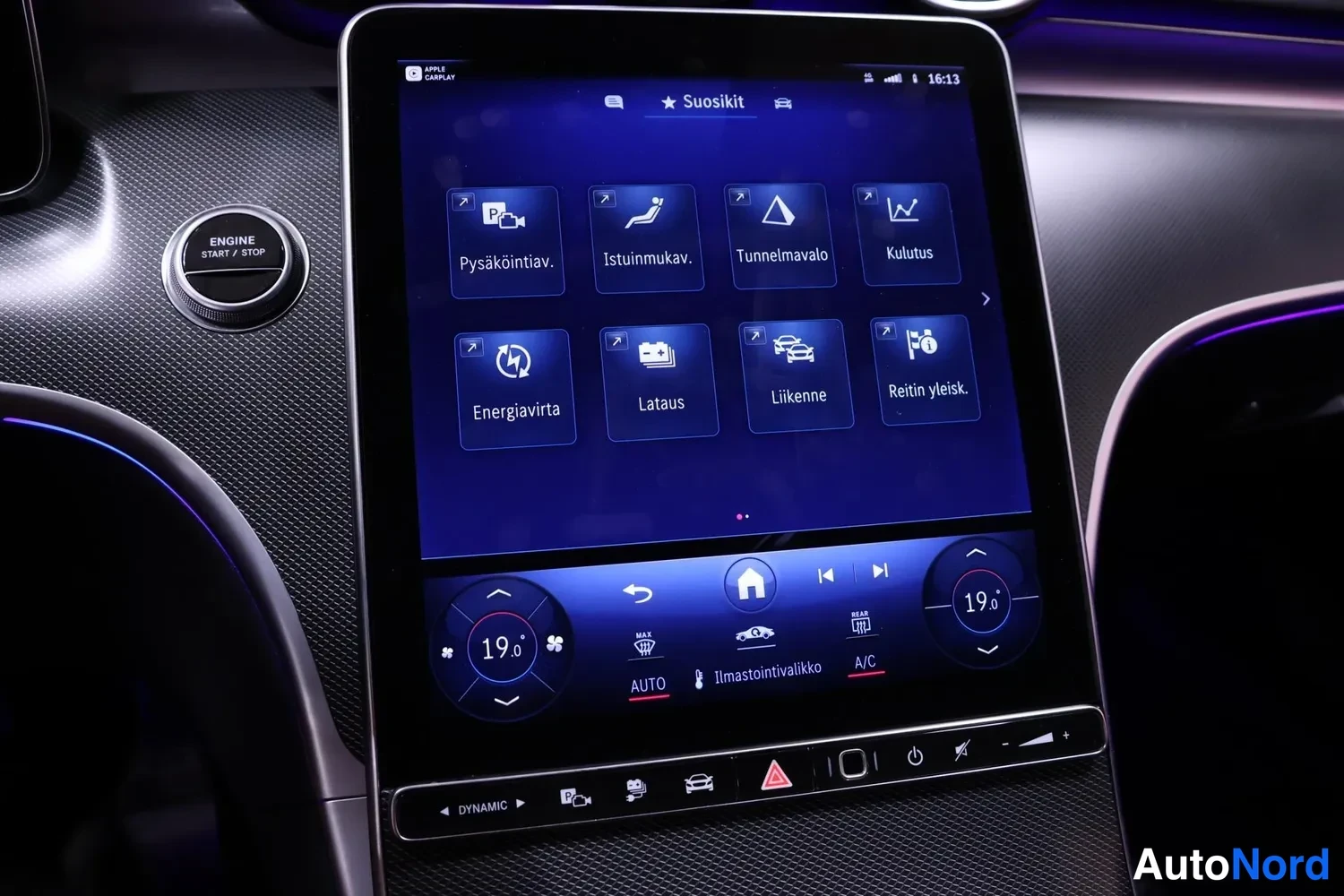 Yksityiskohta: Close-up of the central infotainment display showing a menu titled 'Suositut' (Favorites) with icons for parking aids, seat comfort, interior lighting, and ener