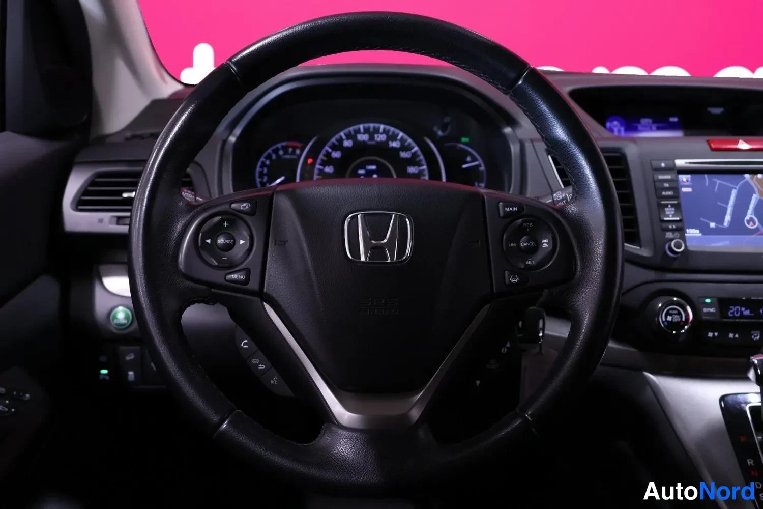 Yksityiskohta: Honda-ohjauspyörä lähikuvassa; nappiryhmät ja kojelaudan mittaristo sekä osa infotainment-näytöstä näkyvissä