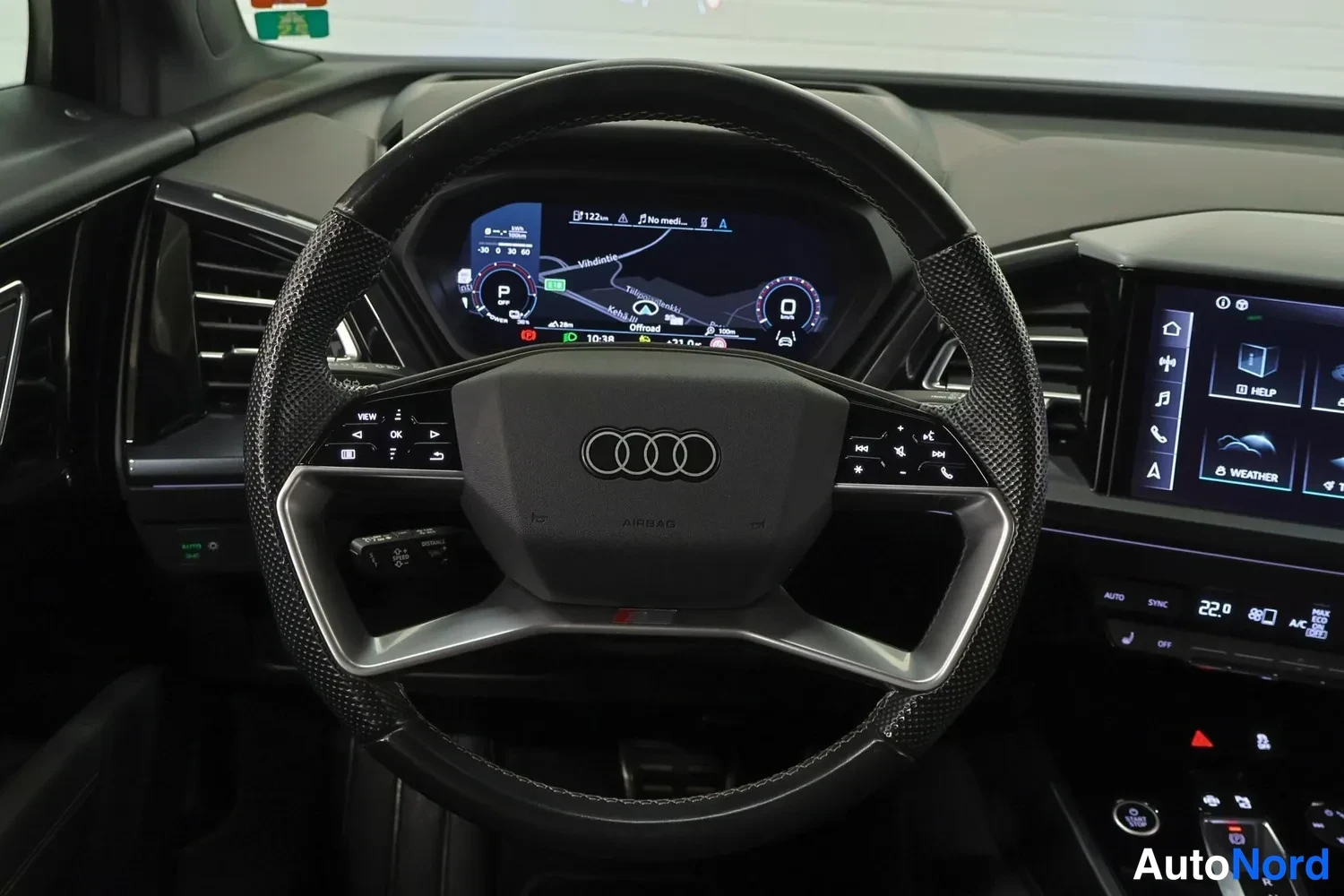 Muu: Ohjauspyörän lähikuva Audi Q4 e-tron:ssa, taustalla digitaalinen mittaristo ja osa keskinäytöstä.