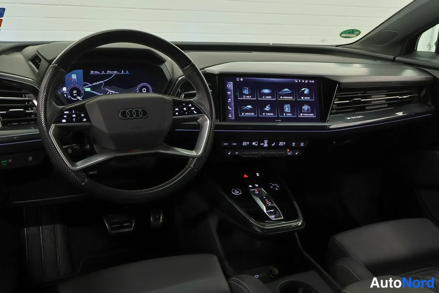Muu: Audi Q4 e-tron -matkustamo etupenkeiltä kuvattuna: ohjauspyörä, digitaalinen mittaristo, suuri keskinäyttö ja musta sisustus.