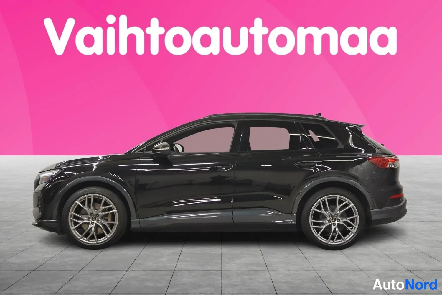 Sivulta: Mustan Audi Q4 e-tronin sivukuva, vasen kylki ja kevytmetallivanteet näkyvissä.