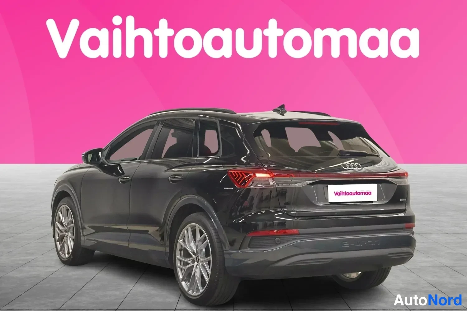 Takaviisto: Mustan Audi Q4 e-tronin takkolävistökuva, takavalot ja oikea kylki näkyvissä.