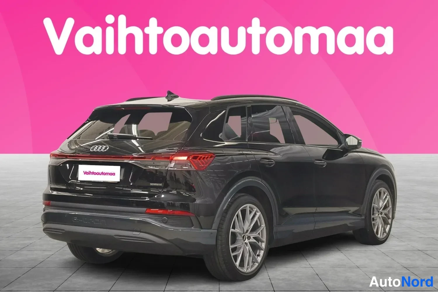 Takaviisto: Musta Audi Q4 e-tron takaa viistosti kuvattuna, takavaloja, nokakansi ja vasen kylki näkyvissä.