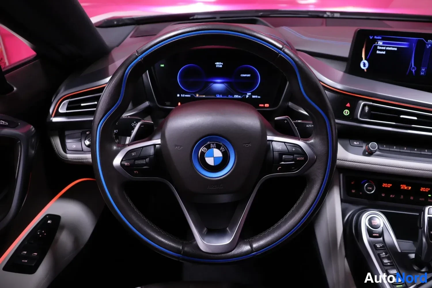 Muu: Ohjaamon näkymä: BMW-ohjauspyörä sinisellä korostuksella, digitaalinen mittaristo ja kosketusnäyttö.