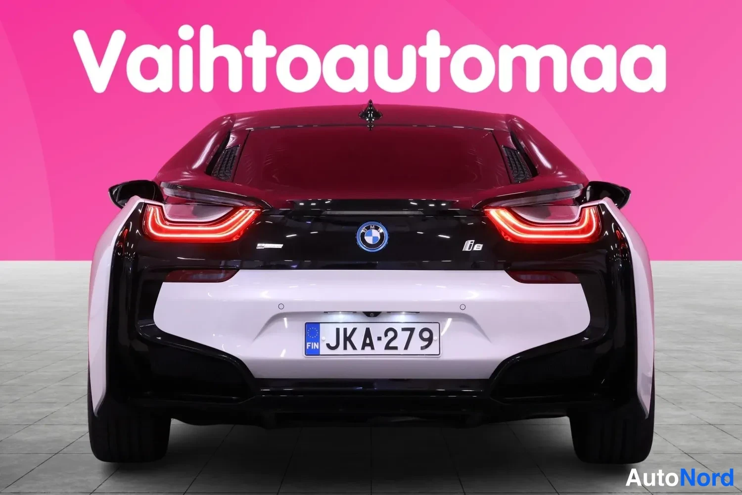Takaa: BMW i8:n takanäkymä: Punaiset U-muotoiset takavalot, musta peräosa ja valkoinen puskuri, rekisteritunnus.