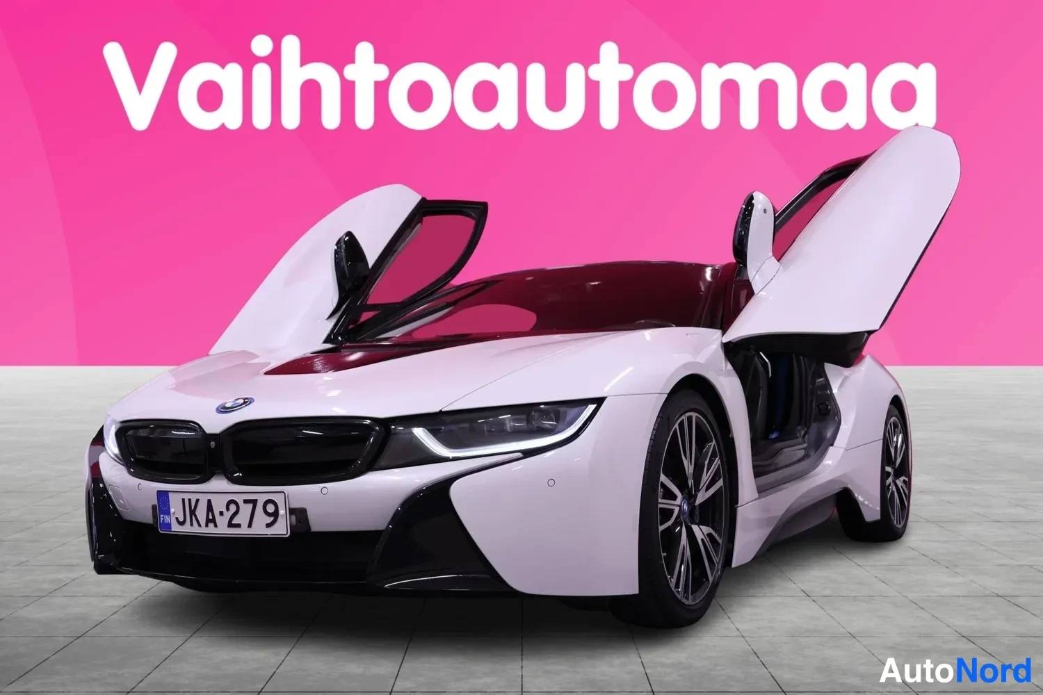 Etuviisto, nokka vasemmalle: BMW-i8:n etunurkkakuva, molemmat perhosteovet auki ylös, valkoinen koristus.