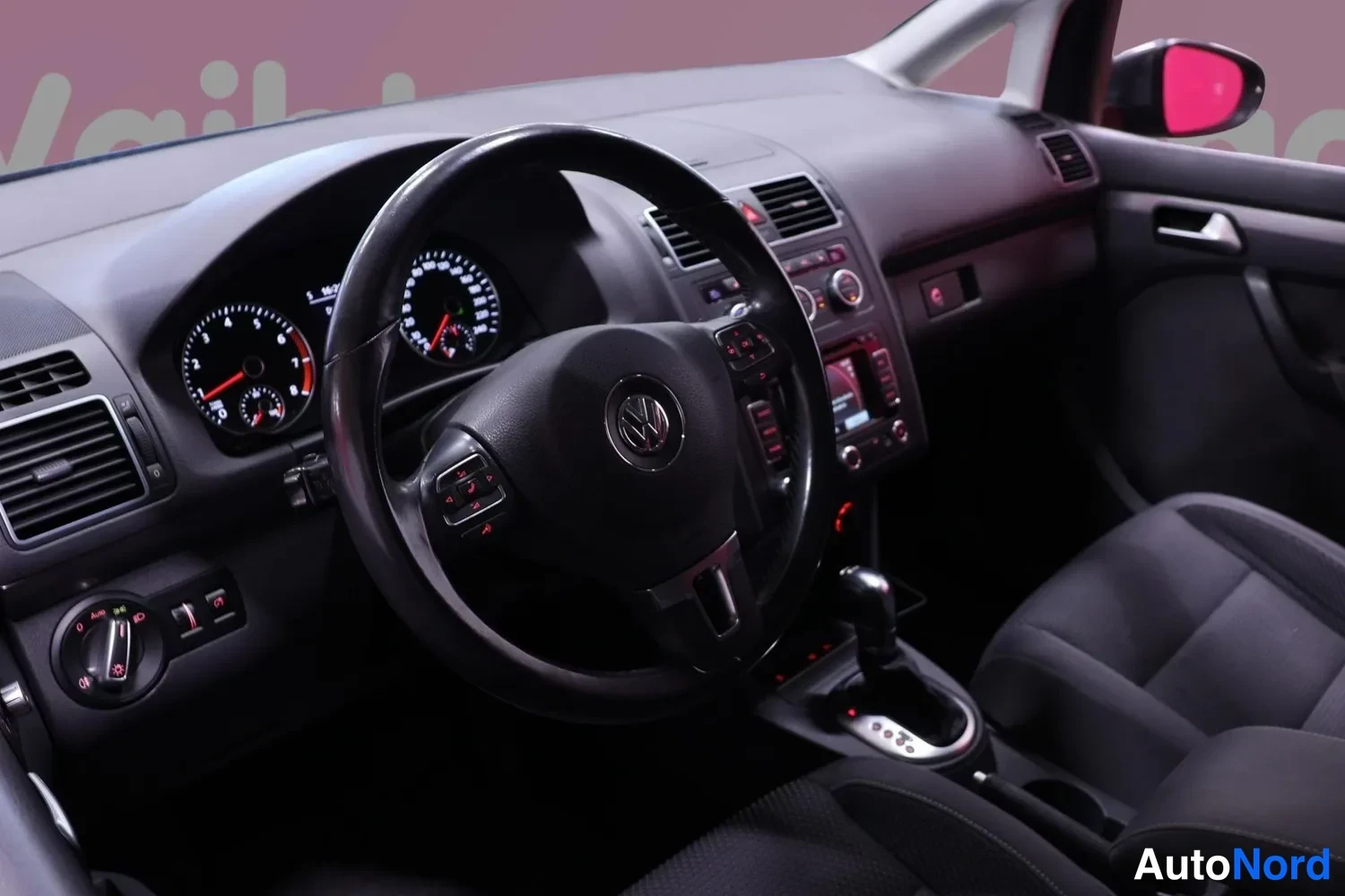 Muu: Ohjaamossa näkyvät VW-merkkinen ohjauspyörä, mittaristo ja automaattivaihteen valitsin.