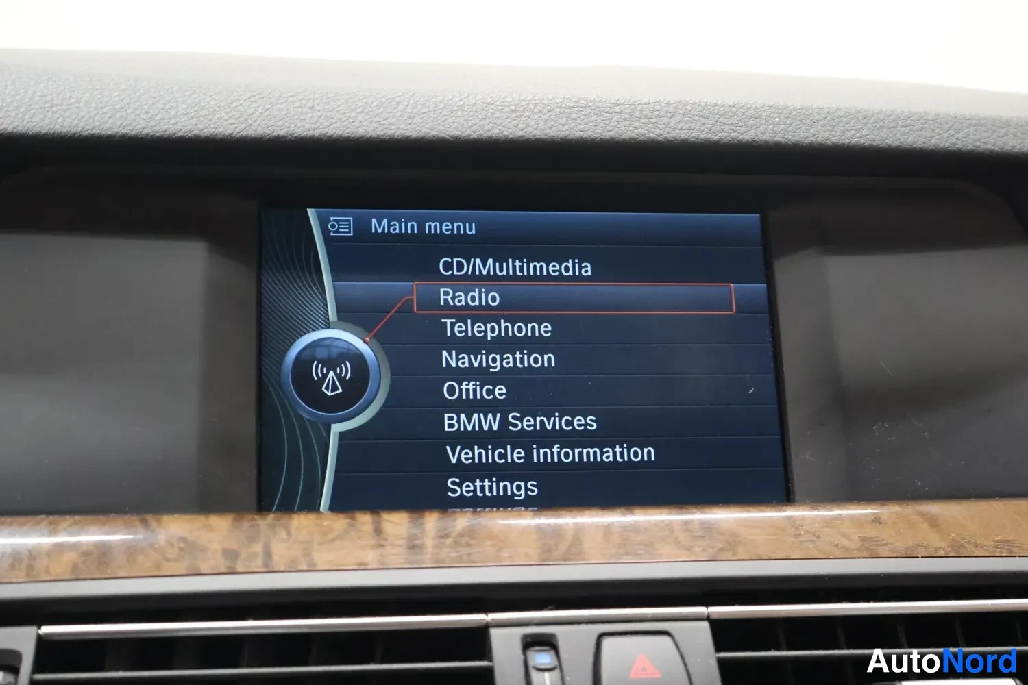 Muu: Kojelaudan infotainment-näyttö päävalikossa, jossa valittuna Radio. Näytössä valikot CD/Multimedia, Telephone, Navigation, Office, BMW Services, Vehicle informa