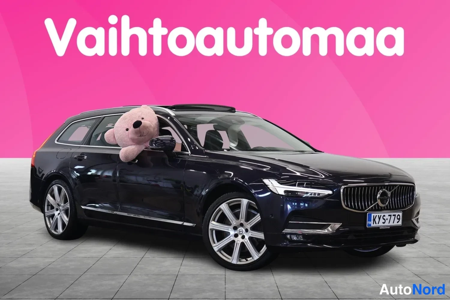Etuviisto, nokka oikealle: Tummansininen Volvo V90 farmari etu kolmannesvasen-näkymä, panoraamakatto auki, rekisterikilpi.