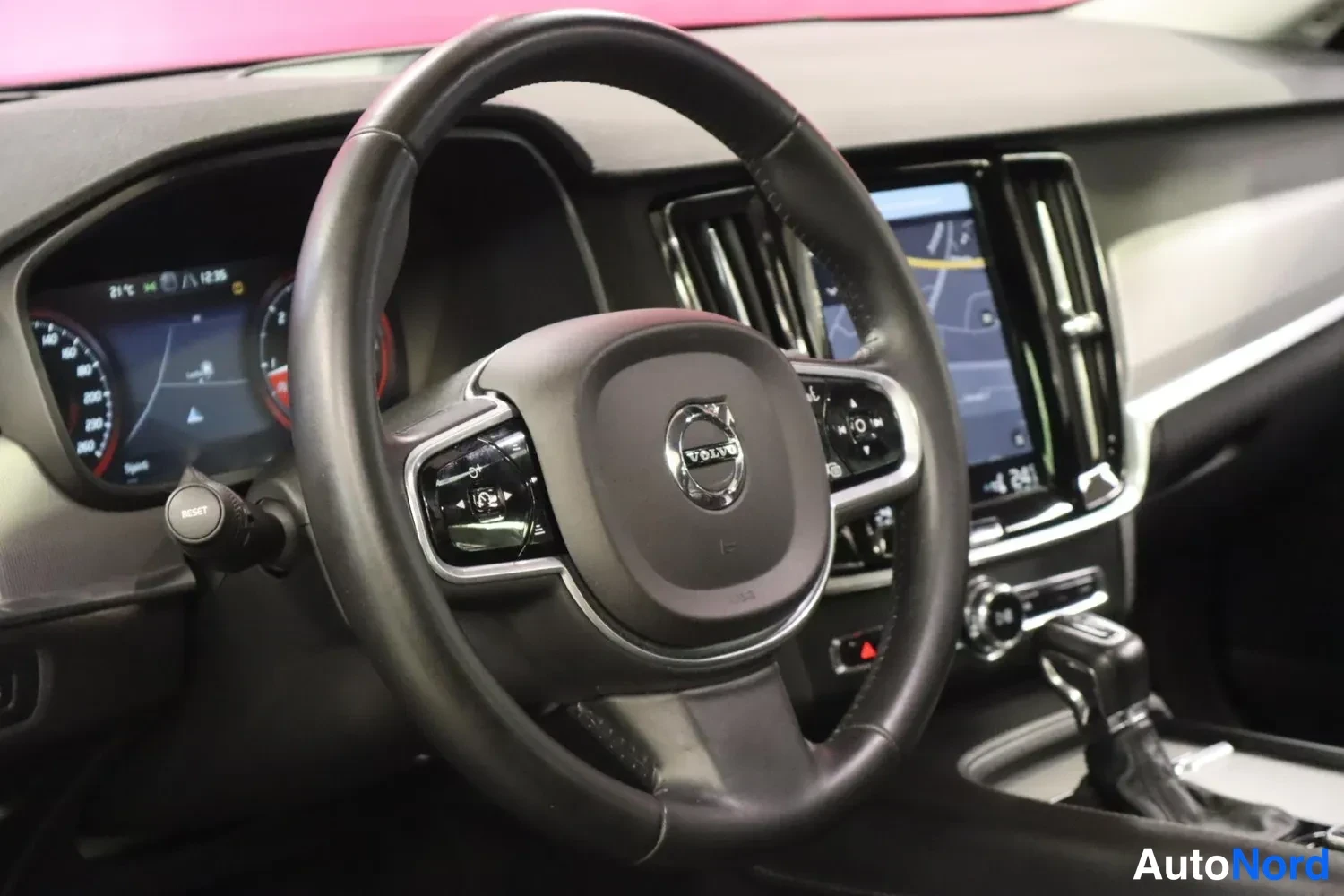Yksityiskohta: Volvo-merkillä varustettu ohjauspyörä ja kojelaudan näytöt.
