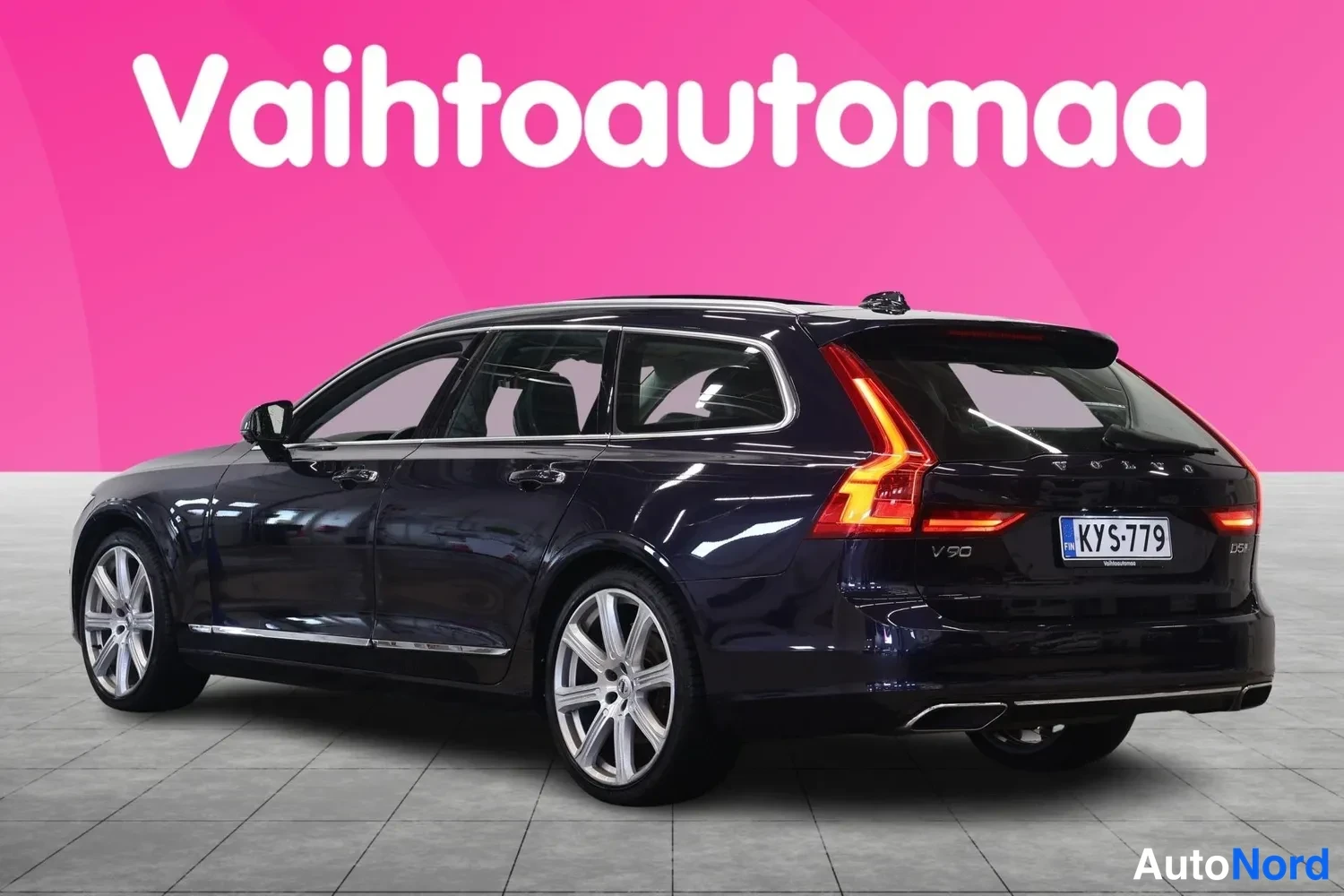 Takaviisto: Tummansininen farmariauto kuvattu takaa viistosti oikealta, rekisterikilpi näkyvissä.