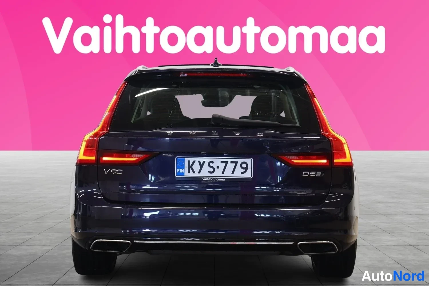 Takaa: Tummansininen farmariauto suoraan takaa, rekisterikilpi ja takavaloat näkyvissä.