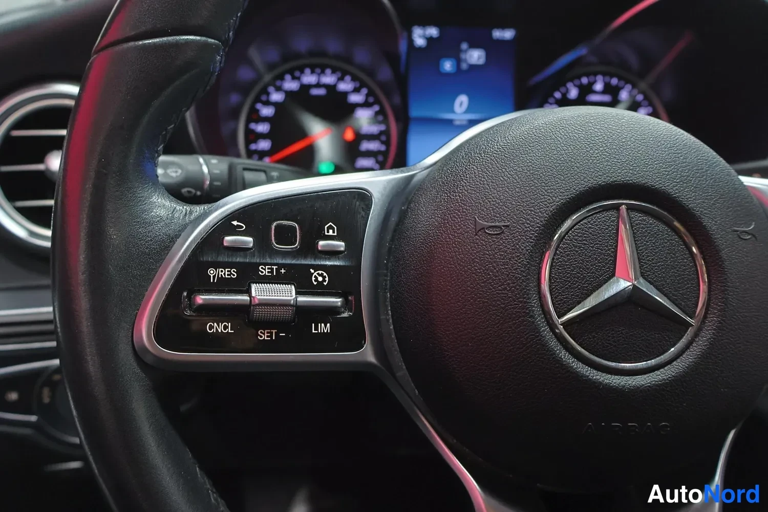 Muu: Mercedes-Benz-ohjauspyörä ja ratti- ja väistövalo-ohjaimet, taustalla mittaristo ja näyttö.