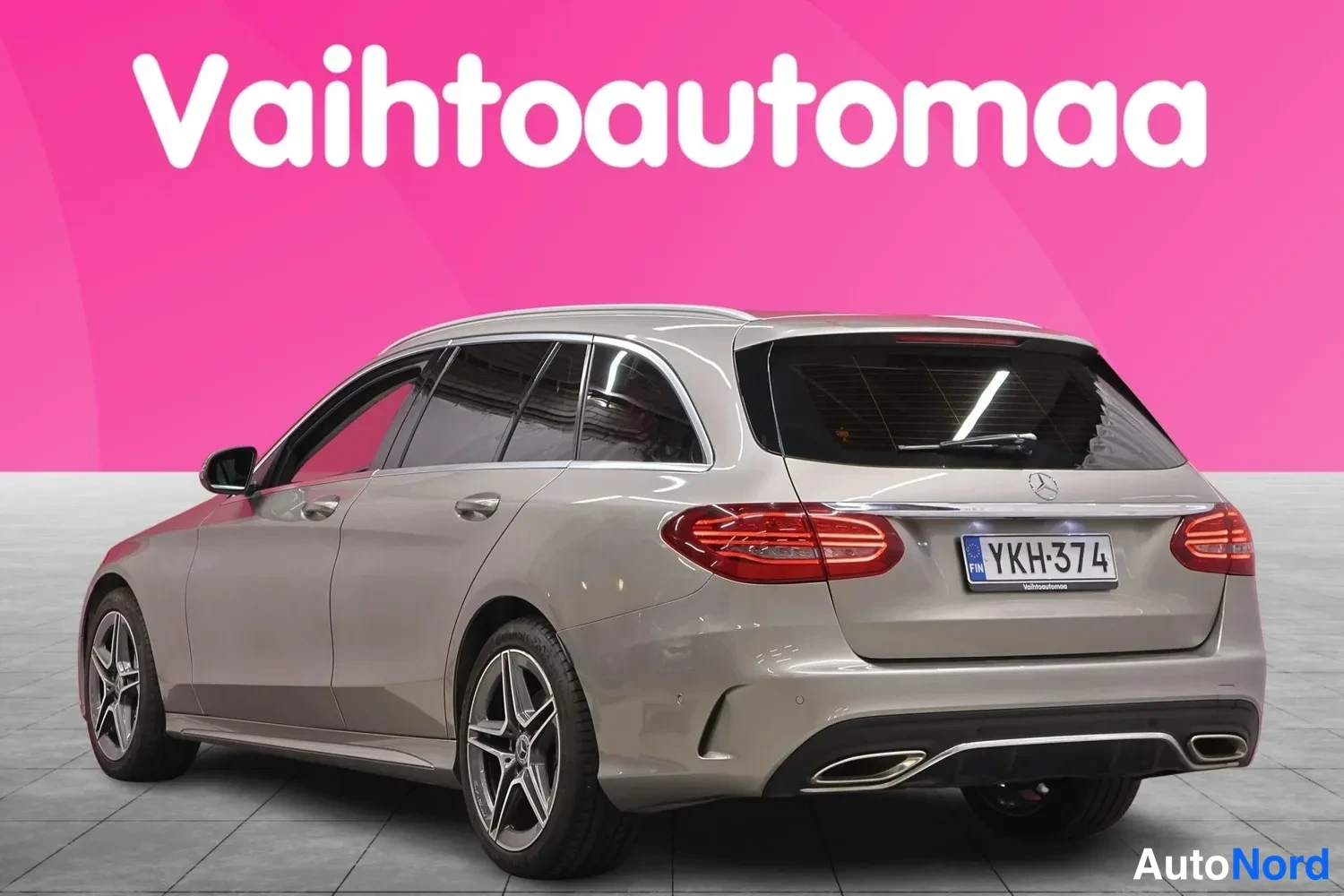Takaviisto: Auton takaosaa ja vasenta kylkeä kolmannesvälistä; Mercedes-tähti ja rekisterikilpi takaluukussa, hopeanvärinen farmarikorinen auto.