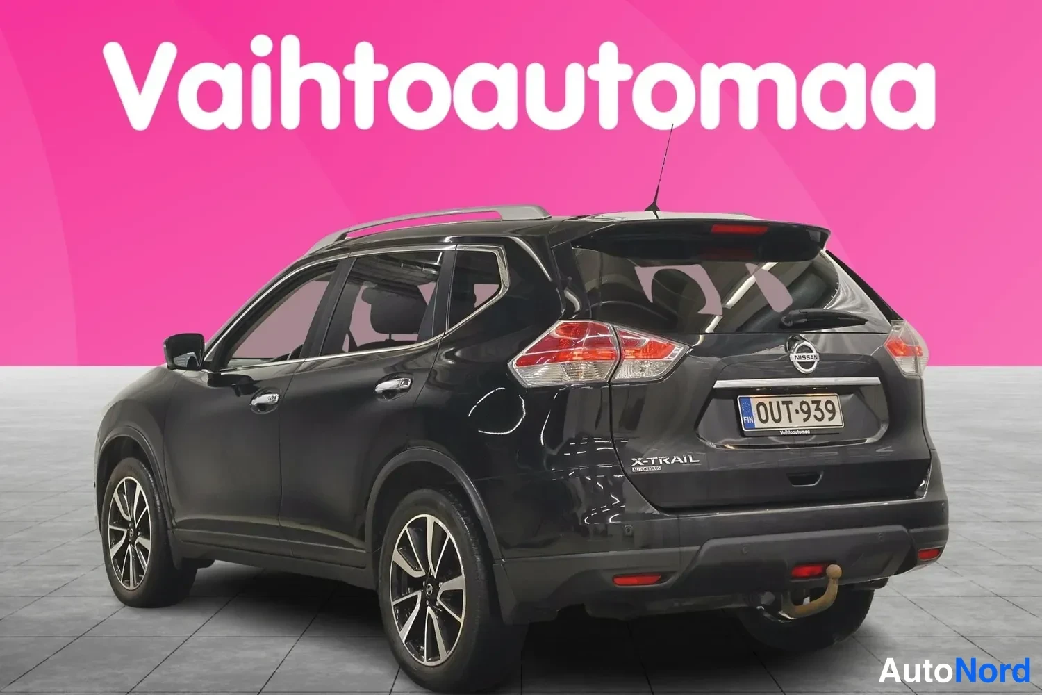 Takaviisto: Mustan farmariauton takakulmakuva, rekisteritunnus ja X-Trail-merkintä takaluukussa.