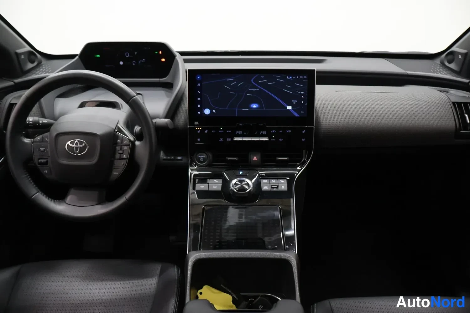 Muu: Ohjaamo ylhäältä: ohjauspyörä Toyota-merkillä, digitaalinen mittaristo, kartan näyttävä kosketusnäyttö ja keskitunneli, jossa pyörivä vaihteenvalitsin.