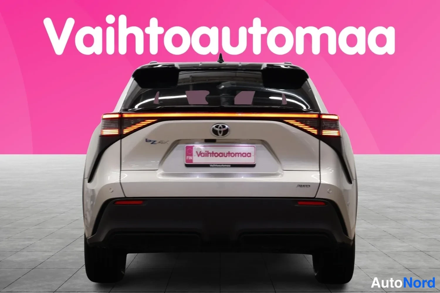 Takaa: Toyota bZ4X:n takaosa suoraan takaa: punaiset takavalot, Toyota-merkki ja Vaihtoautomaan kilpi.