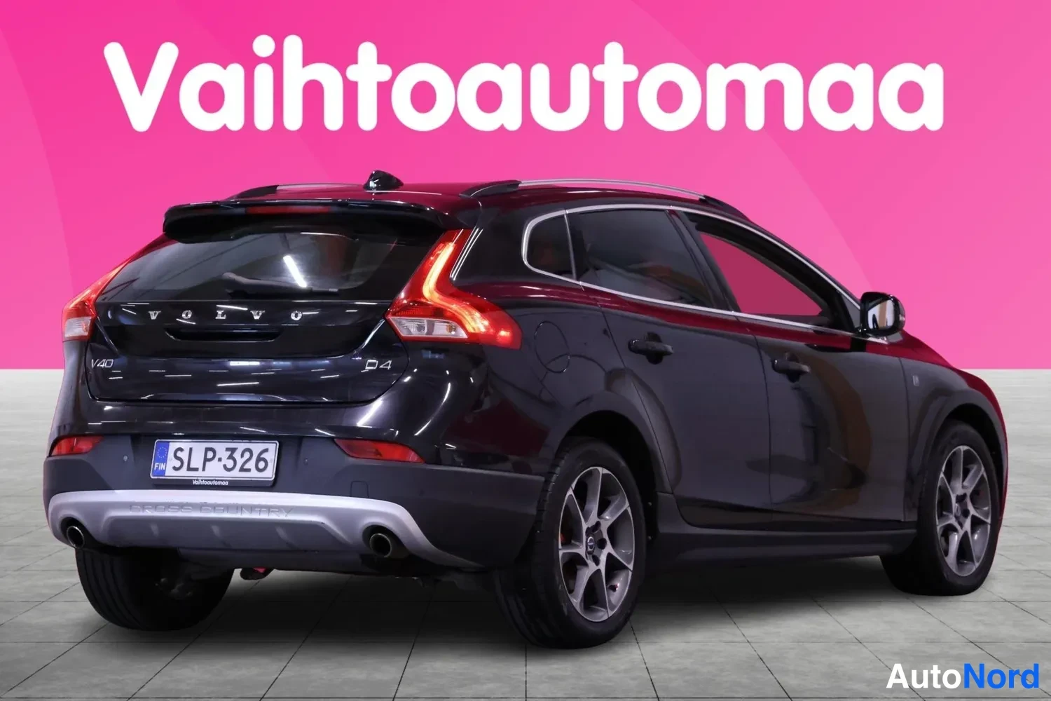 Takaviisto: Musta Volvo takaviistosta: perässä VOLVO-teksti, V40- ja D4-merkit, rekisterikilpi sekä CROSS COUNTRY -teksti takapuskurissa.
