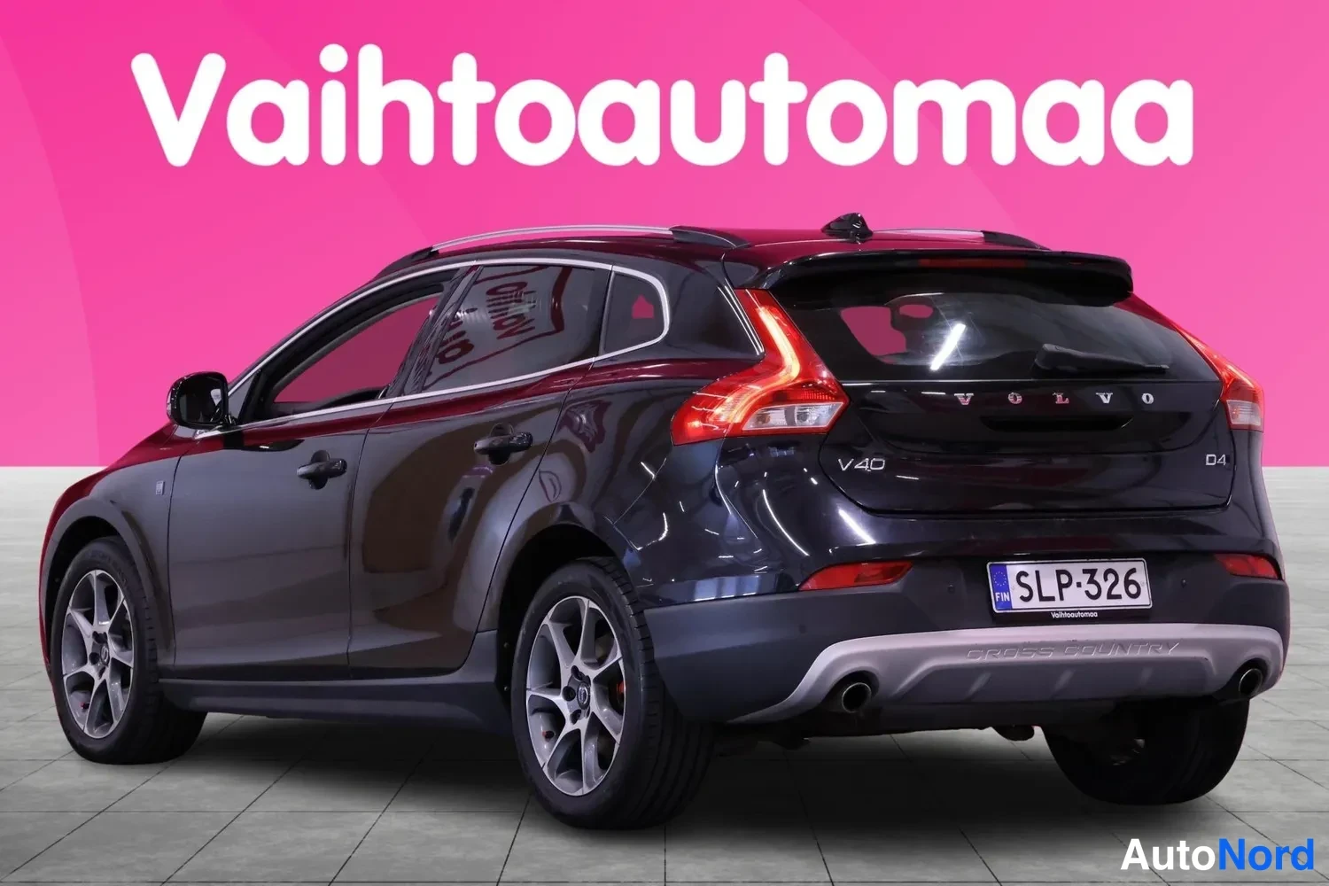 Takaviisto: Mustan Volvo V40:n takaosan kolmisivukuva, rekisterikilpi, CROSS COUNTRY -teksti takapuskurissa.