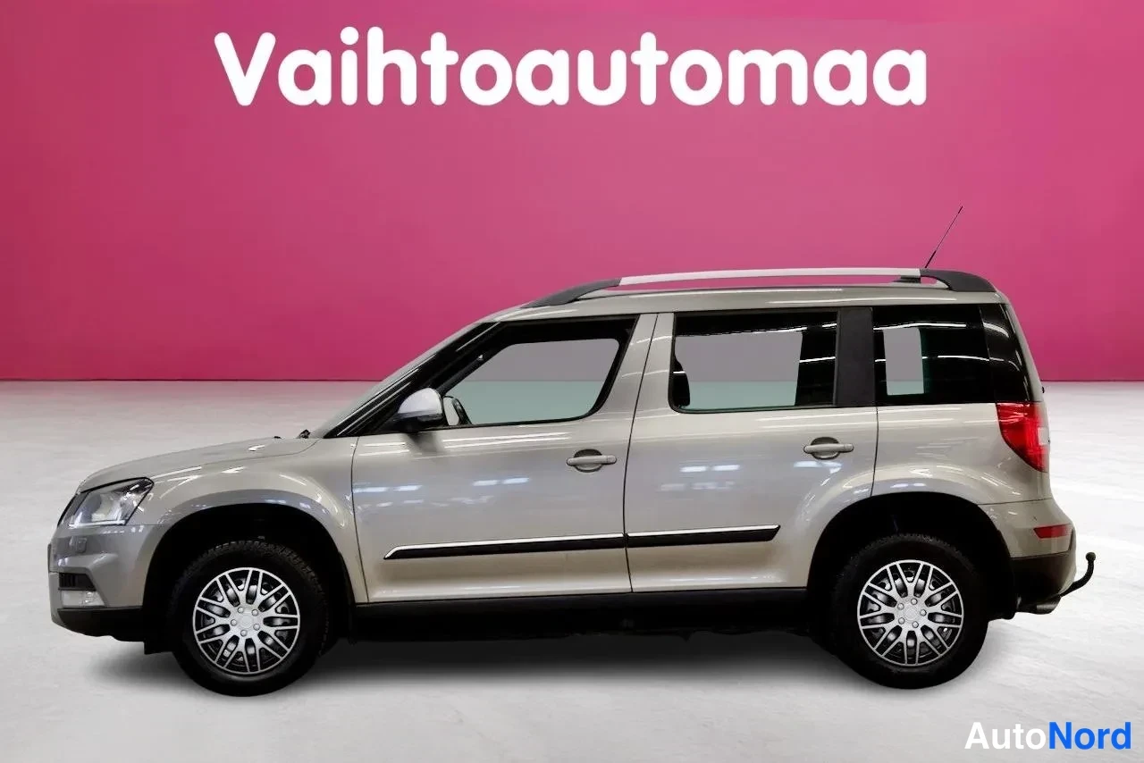 Sivulta: Skoda Yeti sivulta oikealta, beigeasemessa studiovalaistuksessa.