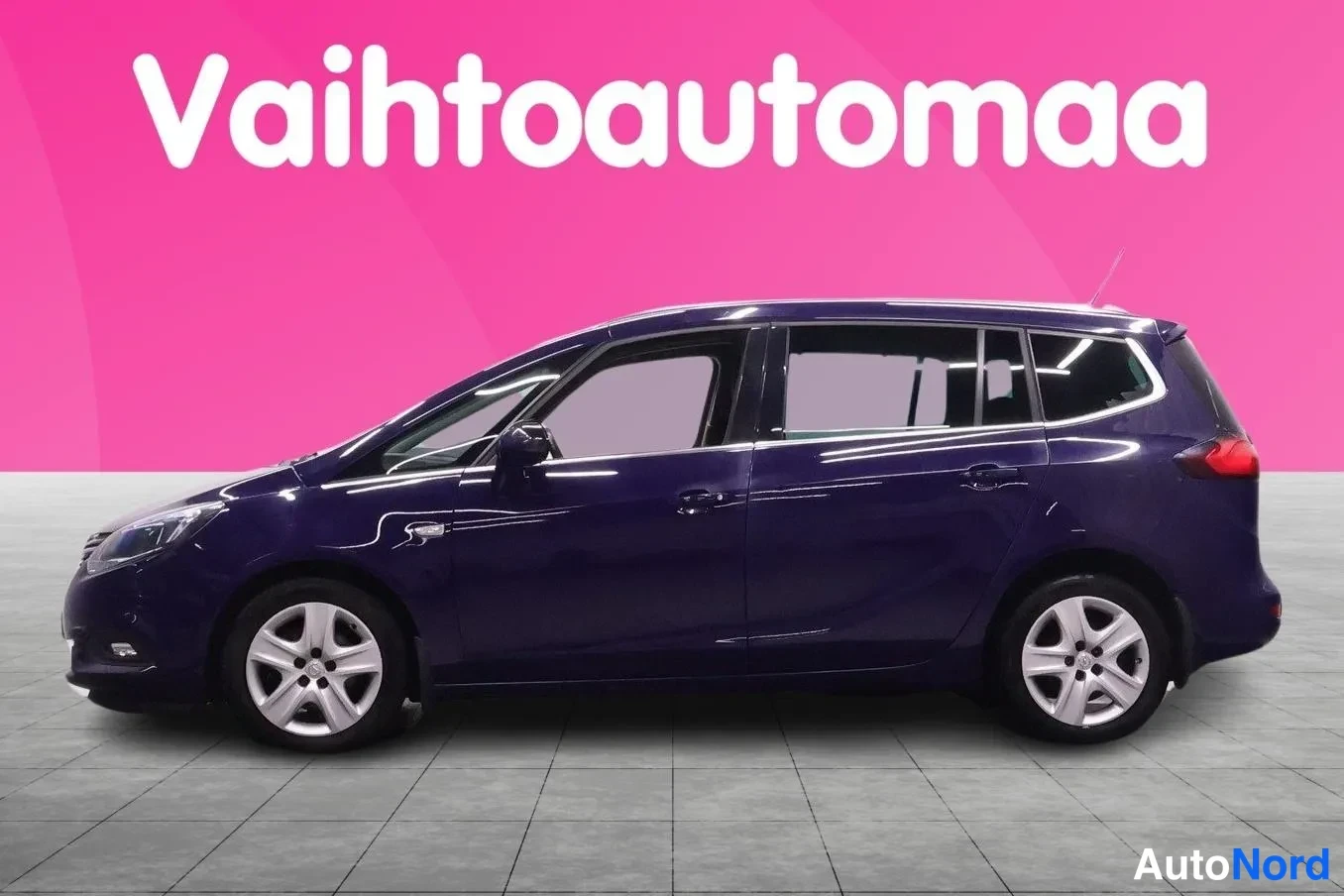 Sivulta: Sininen tila-auto sivusta, vaaleat vanteet