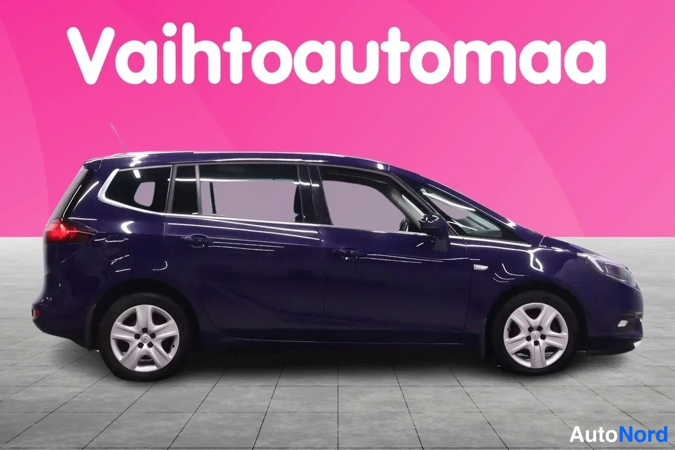 Sivulta: Tummansinisen autocombin sivukuva oikealta puolelta studiossassa.