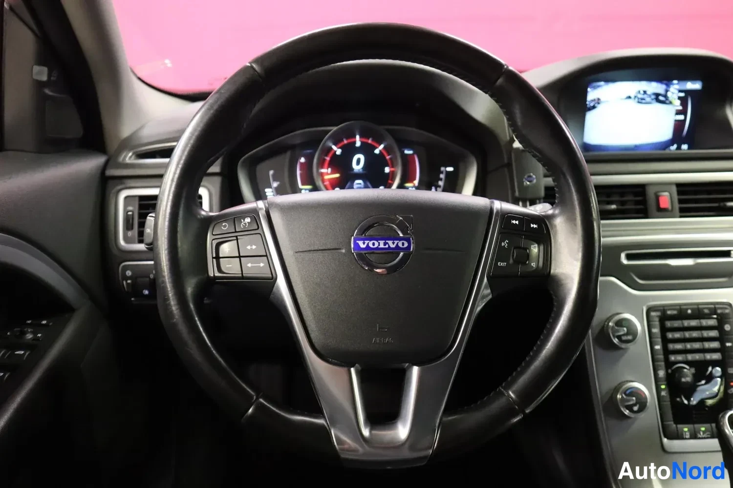 Muu: Volvo-ohjauspyörä kokonaisuudessaan, mittarit näkyvät taustalla ja kamerakuva infotain-näytöllä.