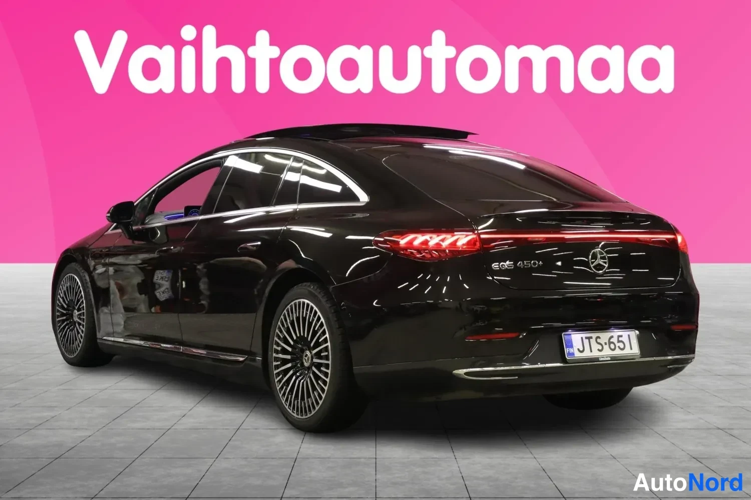 Takaviisto: Mustan Mercedes-Benz EQS:n takanurkkakuva vasemmalta, rekisteri, kattoluukku auki ja punainen takavalaistus.